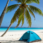 "A pristine, white-sand beach in the Marshall Islands, turquoise water lapping gently at the shore, a lone coconut palm tree providing shade, a tent pitched nearby, camping gear neatly arranged, sunny, peaceful atmosphere, travel photography."